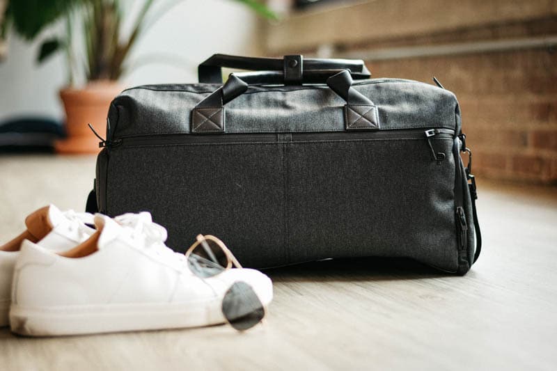 carry-on bag with sneakers and sunglasses